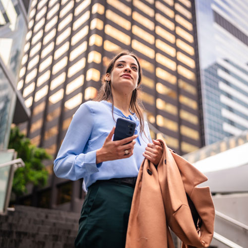 Businesswoman standing in the city holding a mobile phone