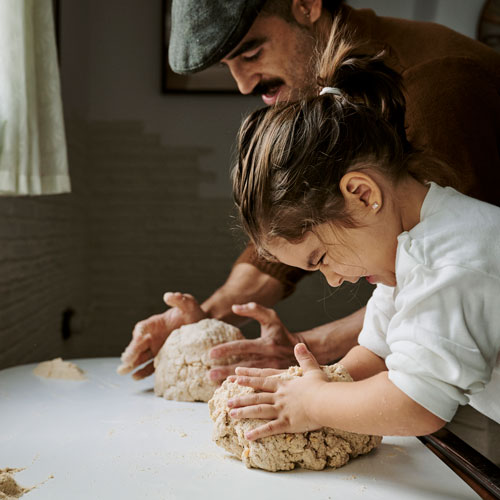 girl and father kneading dough