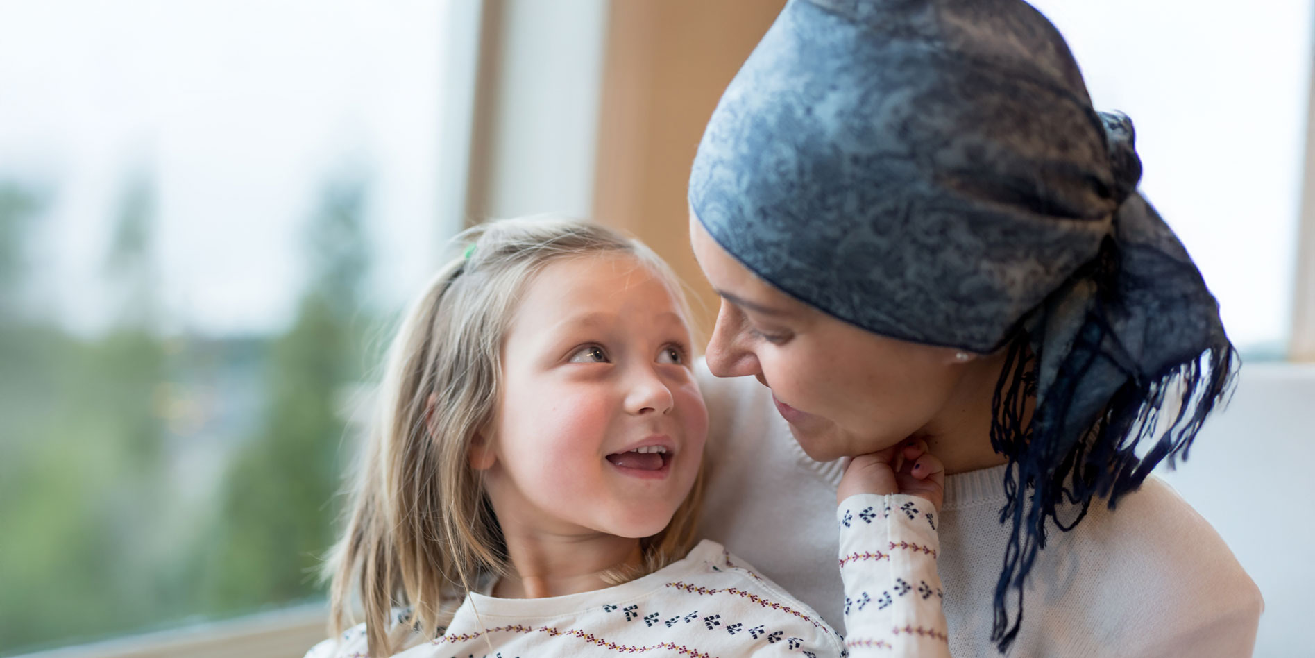 young girl looking at mother with head scarf